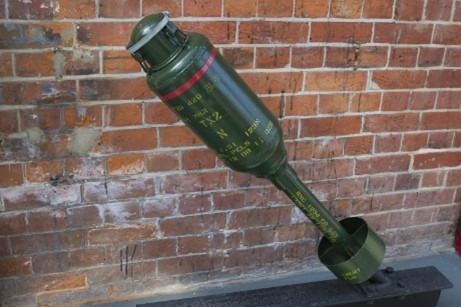 A green bomb on a brick wall  Description automatically generated